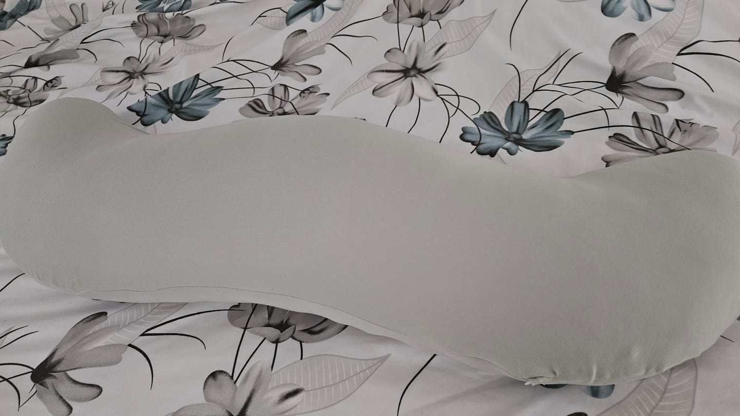 Customer's grey Snuggi™ Cooling Pillowcase on a floral patterned bed sheet.