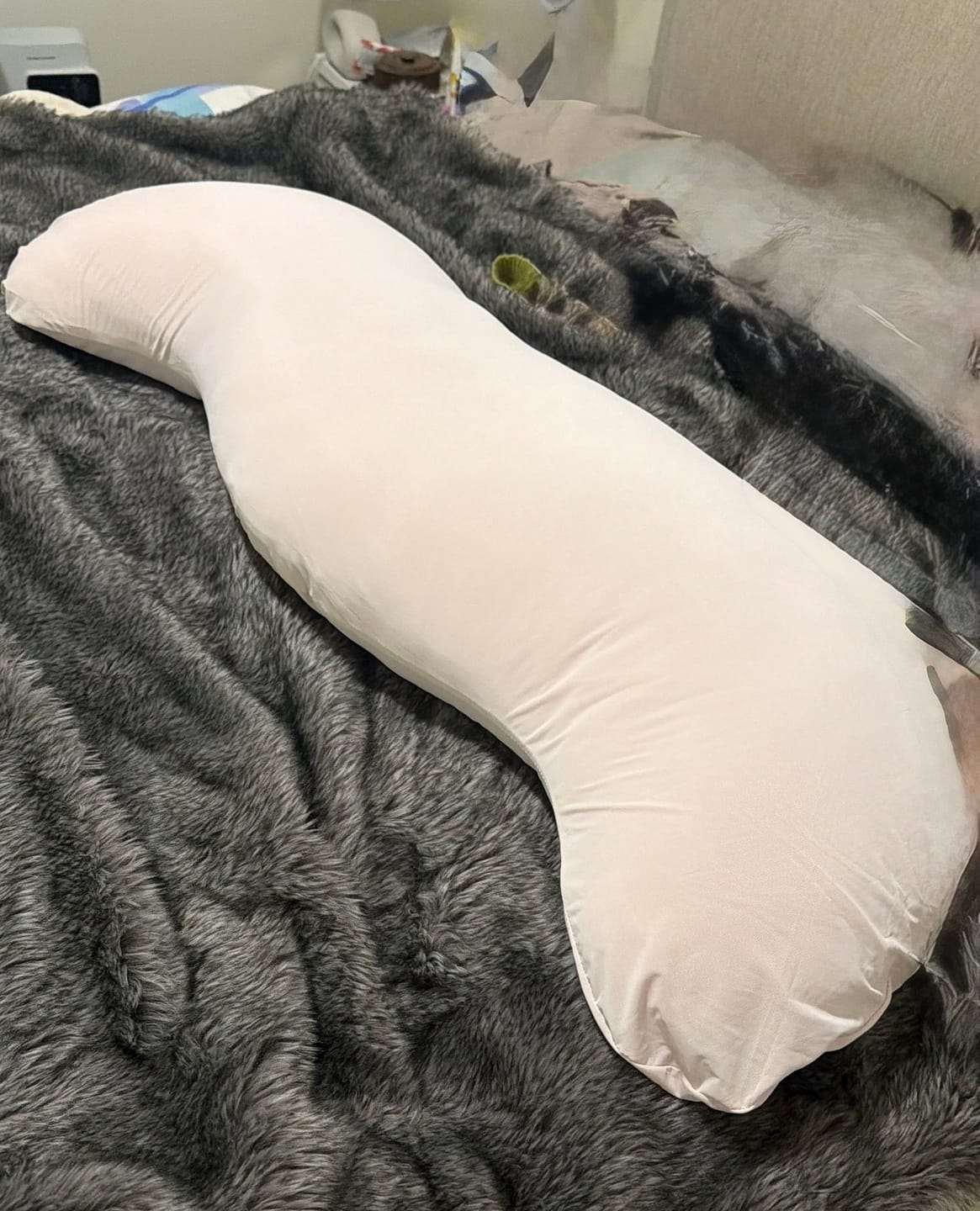 Customer's Snuggi Cooling Pillow Case, a long, light-colored body pillow cover resting on a soft, dark gray blanket.
